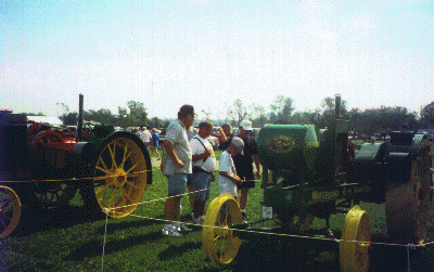 people standing around a tractor at a show